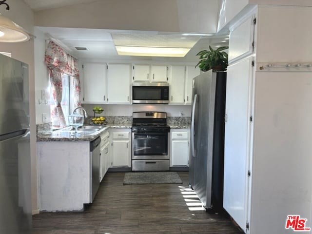 kitchen with white cabinets, sink, light stone countertops, appliances with stainless steel finishes, and dark hardwood / wood-style flooring