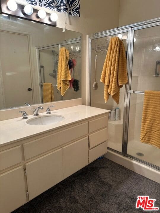 bathroom with vanity and a shower with door