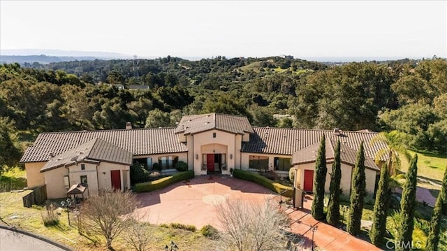 1450 Sugar Bush Ct, Arroyo Grande, CA 93420 - mediterranean / spanish-style house featuring stucco siding, a tiled roof, a forest view, and a chimney