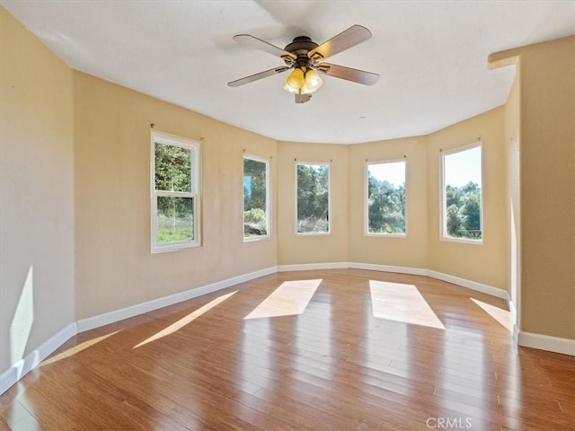 unfurnished room featuring ceiling fan, plenty of natural light, and light wood-type flooring