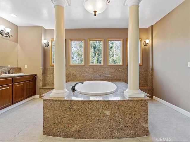 bathroom with vanity, tile patterned flooring, tiled bath, and ornate columns