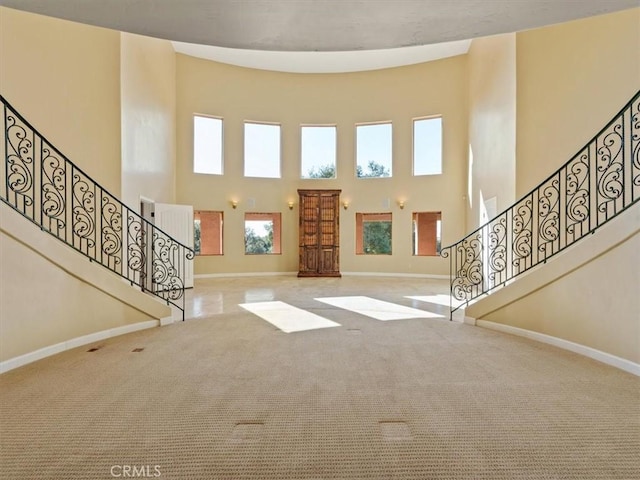 entrance foyer featuring light colored carpet and a high ceiling