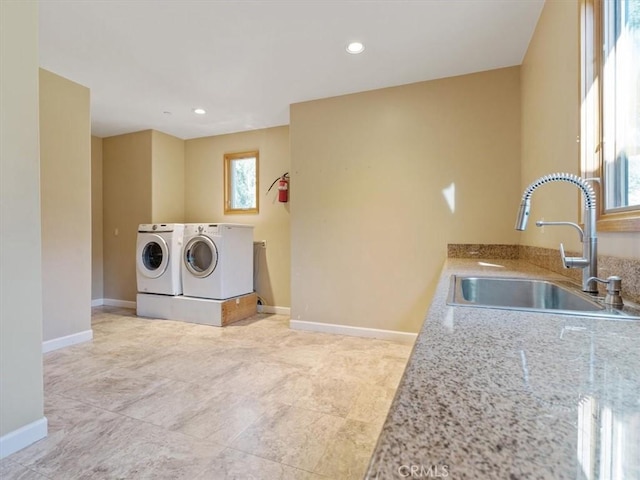 clothes washing area with sink and washing machine and clothes dryer