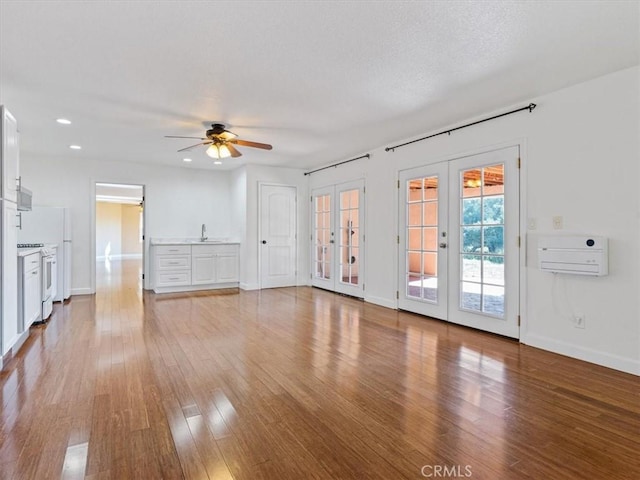 1450 Sugar Bush Ct, Arroyo Grande, CA 93420 - unfurnished living room featuring french doors, a sink, wood finished floors, a ceiling fan, and baseboards