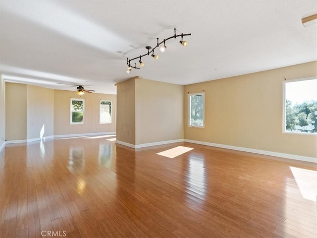 empty room with plenty of natural light and light hardwood / wood-style flooring