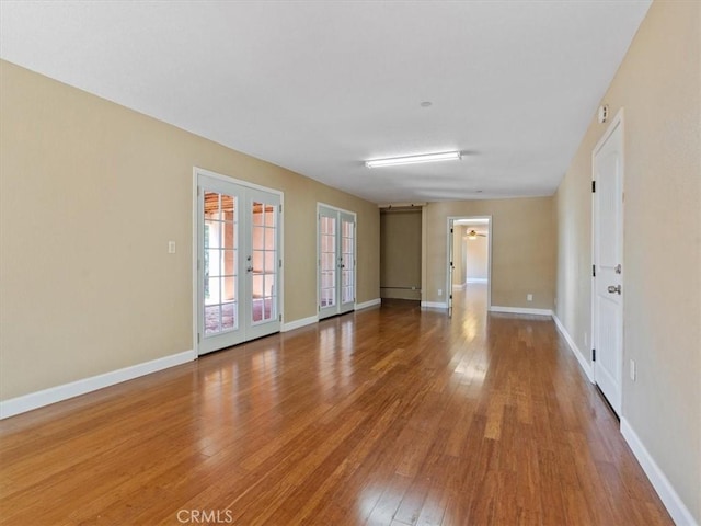 unfurnished room with hardwood / wood-style flooring and french doors