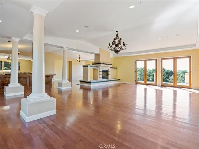 unfurnished living room with decorative columns, wood-type flooring, lofted ceiling, and french doors