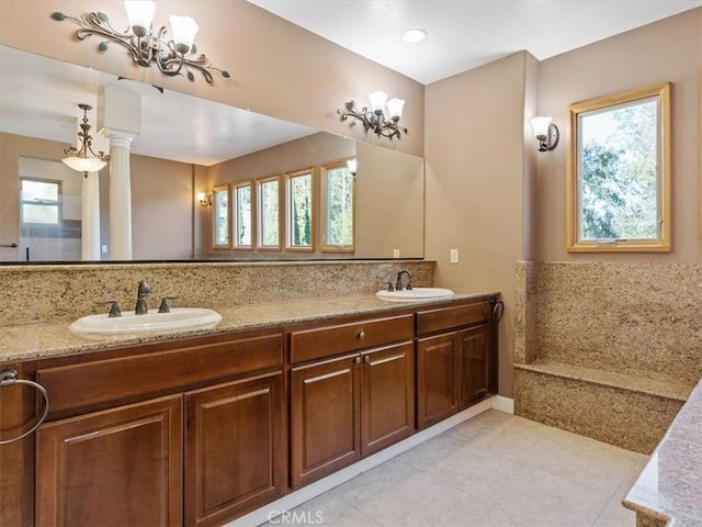 bathroom featuring tile patterned flooring, vanity, a healthy amount of sunlight, and a notable chandelier