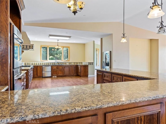 1450 Sugar Bush Ct, Arroyo Grande, CA 93420 - kitchen featuring brown cabinets, stainless steel appliances, a chandelier, light wood-type flooring, and lofted ceiling