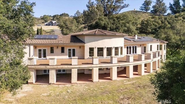 1450 Sugar Bush Ct, Arroyo Grande, CA 93420 - back of property featuring solar panels, a balcony, stucco siding, and a tiled roof