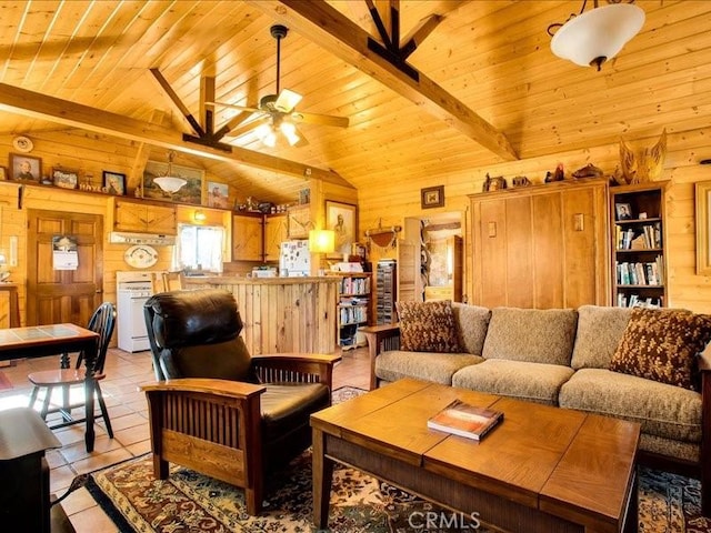 tiled living room featuring beamed ceiling, ceiling fan, and wood walls