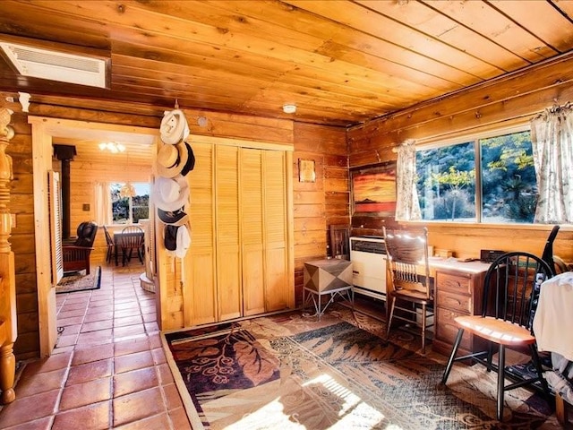 sitting room with tile patterned flooring, wood walls, and wood ceiling