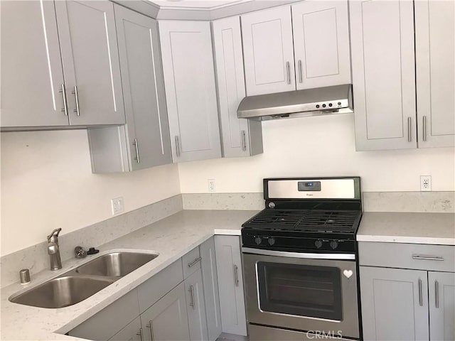 kitchen featuring gray cabinetry, light stone counters, sink, and stainless steel range with gas stovetop