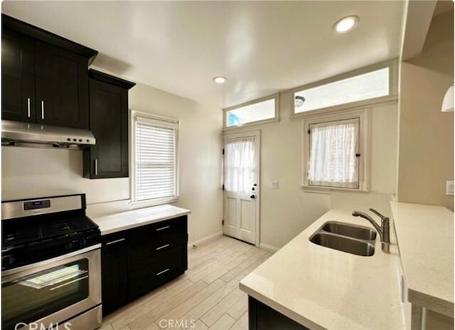 kitchen with stainless steel gas stove, light wood-type flooring, and sink