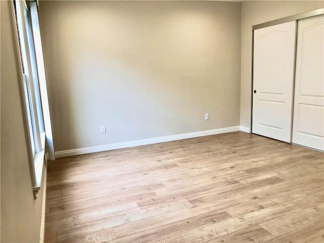 unfurnished bedroom featuring a closet and light hardwood / wood-style flooring