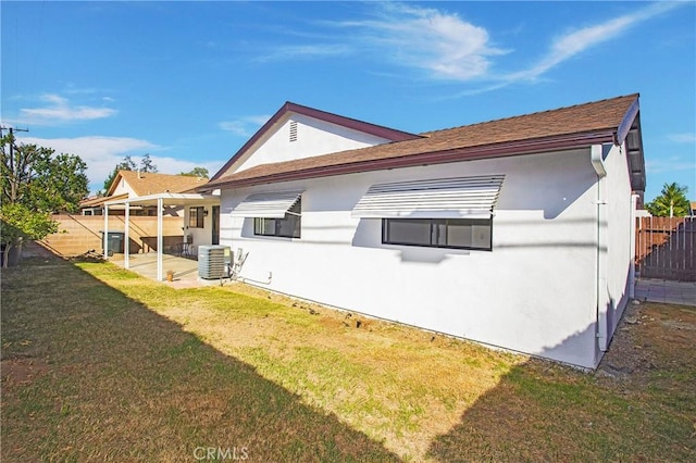 back of property featuring central AC and a yard