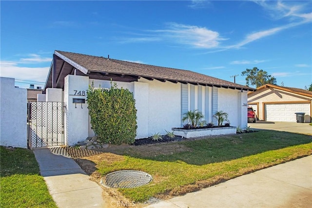 view of front of property featuring a garage and a front lawn