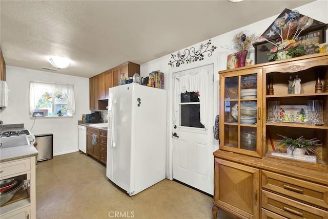 kitchen featuring a textured ceiling and white appliances