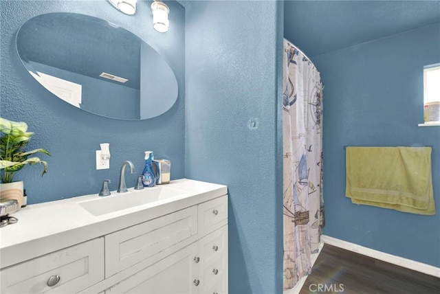 full bathroom featuring a shower with curtain, vanity, baseboards, and wood finished floors