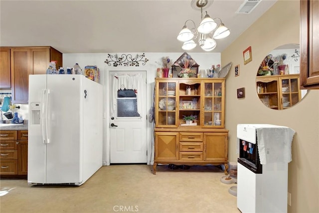 kitchen with pendant lighting, light colored carpet, white fridge with ice dispenser, and an inviting chandelier