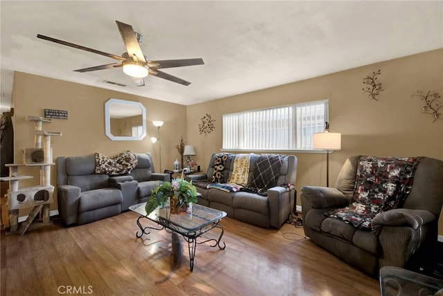 living room with visible vents, ceiling fan, and wood finished floors