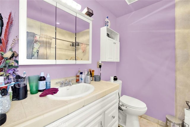 bathroom with tile patterned flooring, vanity, and toilet