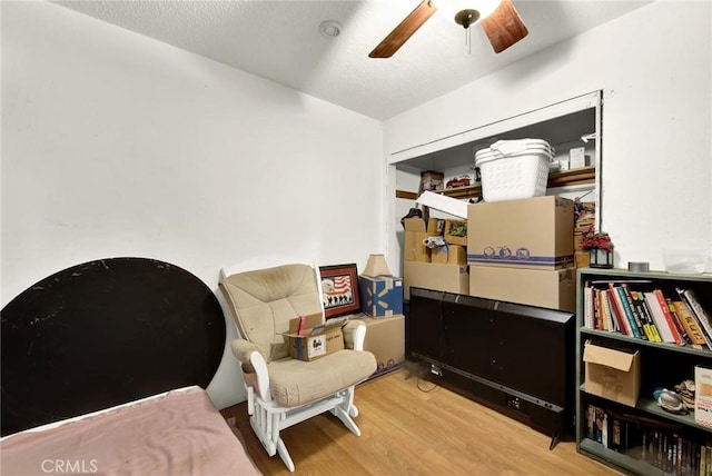 living area with ceiling fan and wood-type flooring