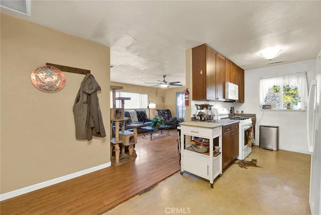 kitchen featuring a textured ceiling, white appliances, and ceiling fan