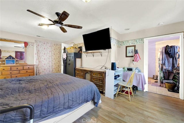 bedroom featuring ceiling fan, light hardwood / wood-style floors, and a closet