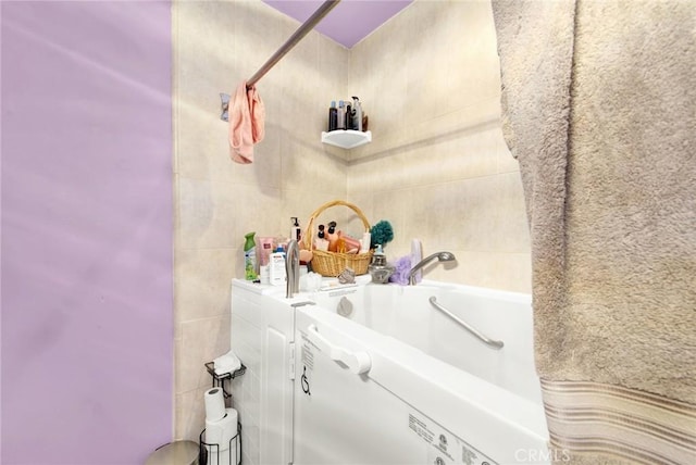 full bathroom featuring tile walls, a shower with shower curtain, and a bathing tub