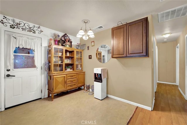 kitchen featuring an inviting chandelier, baseboards, and visible vents