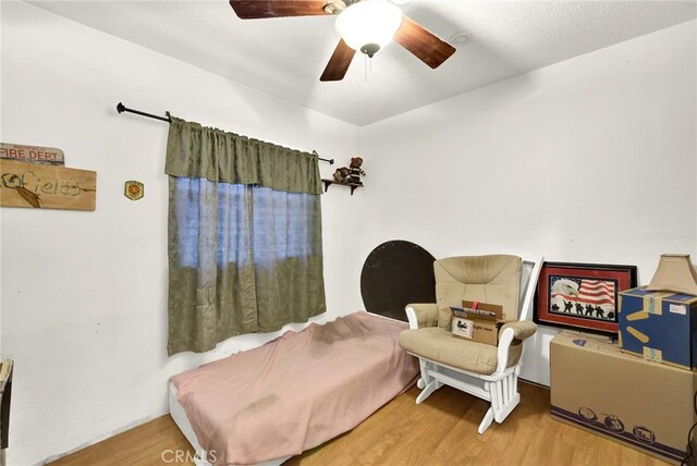 sitting room featuring ceiling fan and wood finished floors