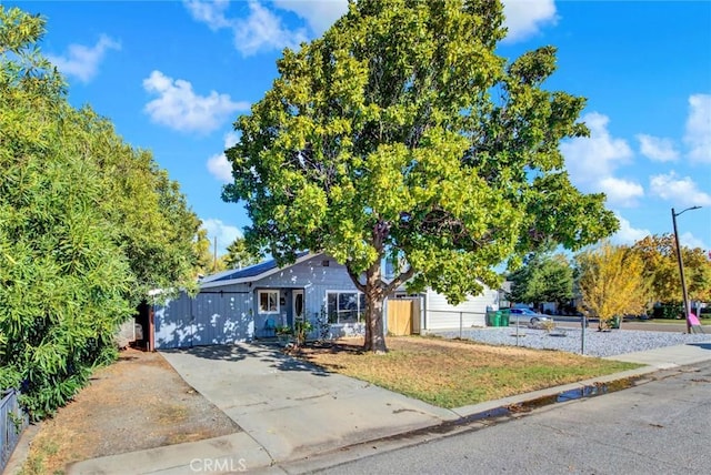 view of front of home with a front yard, fence, and solar panels