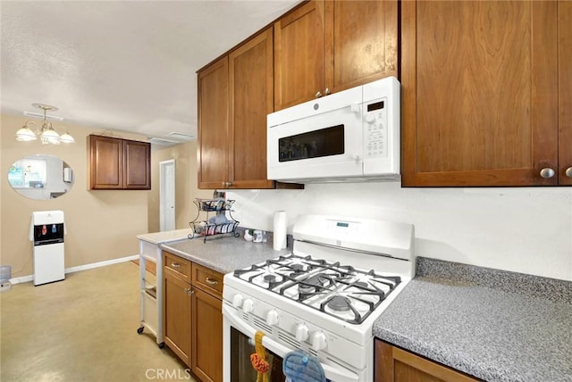 kitchen featuring white appliances, hanging light fixtures, and a notable chandelier