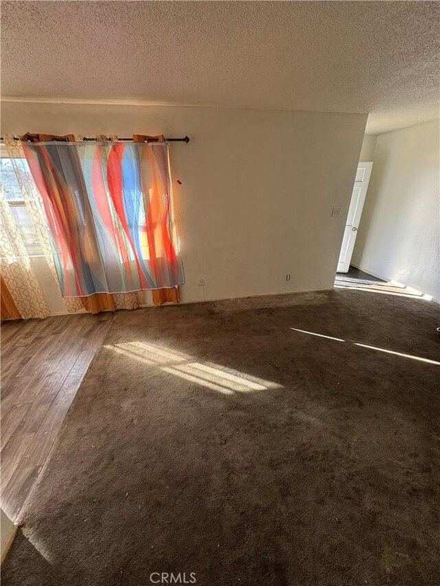 unfurnished room with wood-type flooring and a textured ceiling