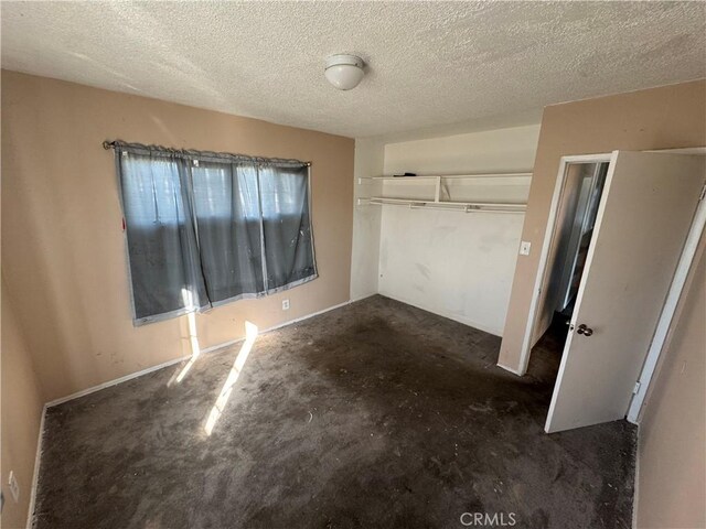 unfurnished bedroom featuring a textured ceiling and a closet