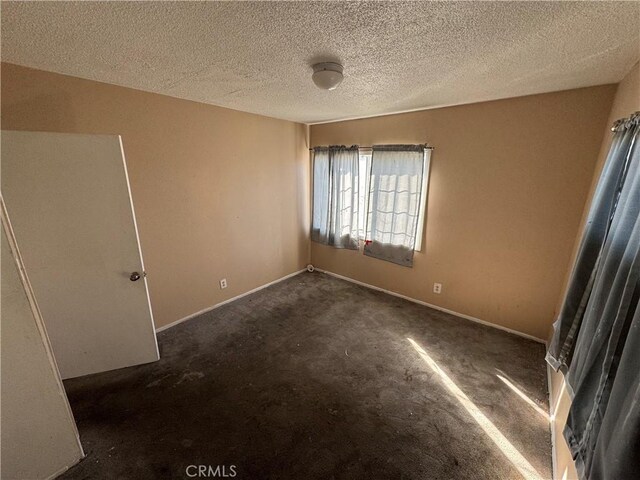 carpeted spare room featuring a textured ceiling