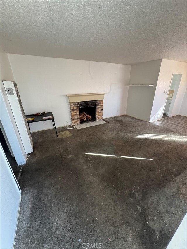 unfurnished living room featuring a fireplace and a textured ceiling