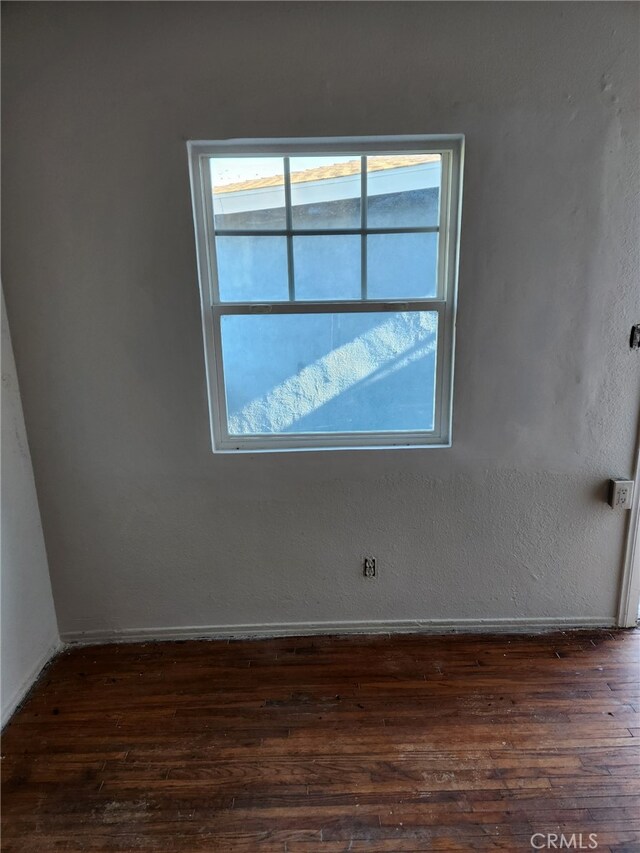 unfurnished room with dark wood-type flooring