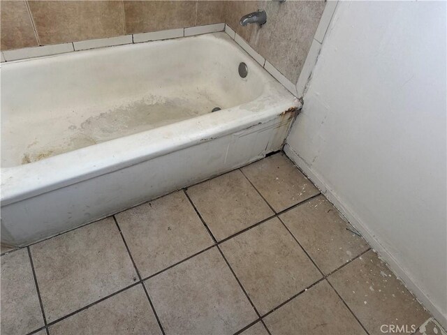 bathroom with a washtub and tile patterned floors