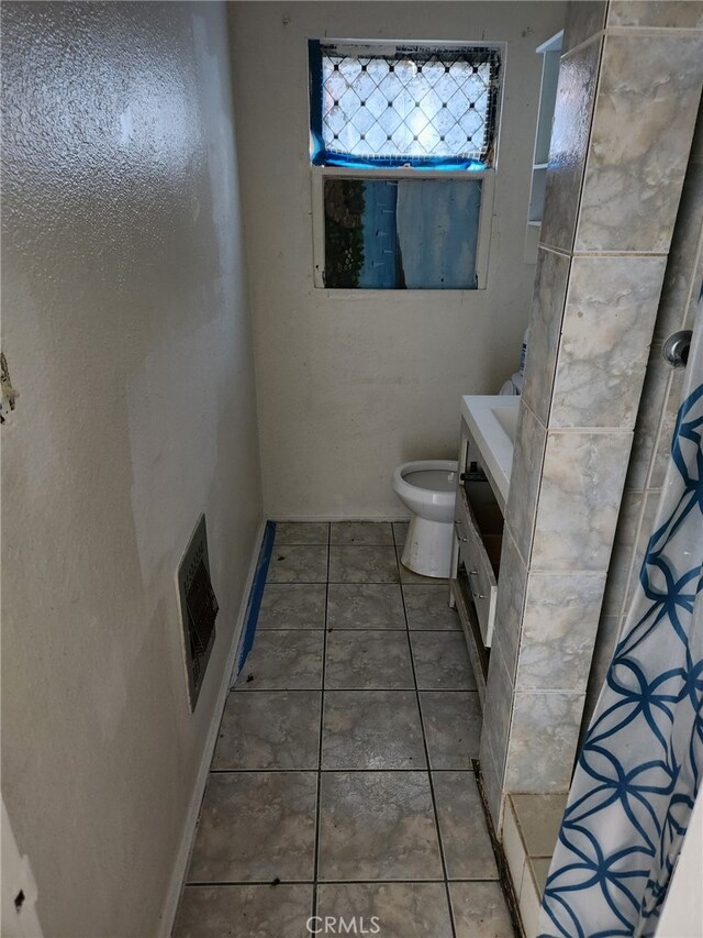 bathroom featuring tile patterned floors, vanity, toilet, and a shower with shower curtain