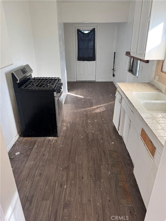 kitchen with black gas range, white cabinetry, tile counters, tasteful backsplash, and dark hardwood / wood-style flooring