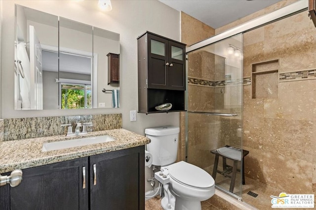 bathroom featuring tile patterned floors, vanity, toilet, and an enclosed shower