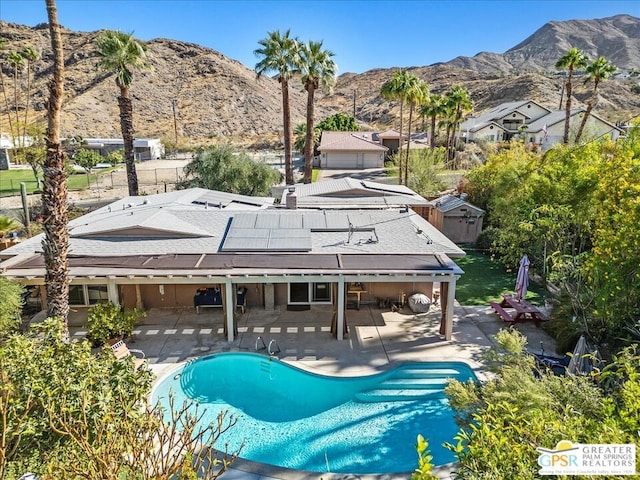 view of swimming pool featuring a mountain view and a patio area