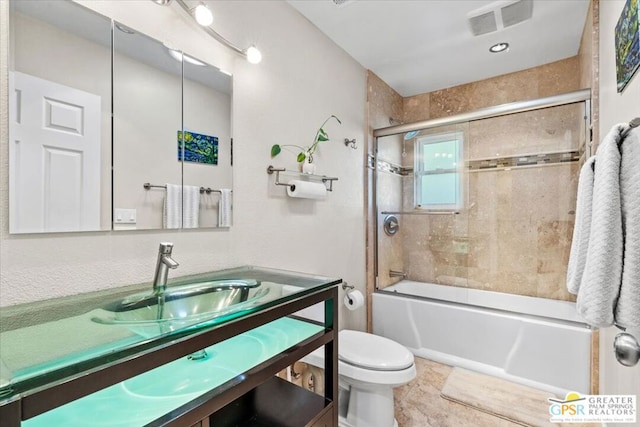 full bathroom with tile patterned floors, toilet, combined bath / shower with glass door, and vanity