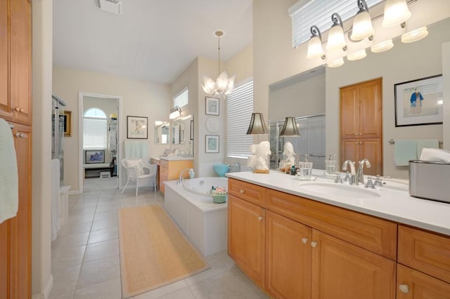 bathroom with tile patterned floors, tiled bath, vanity, and a notable chandelier