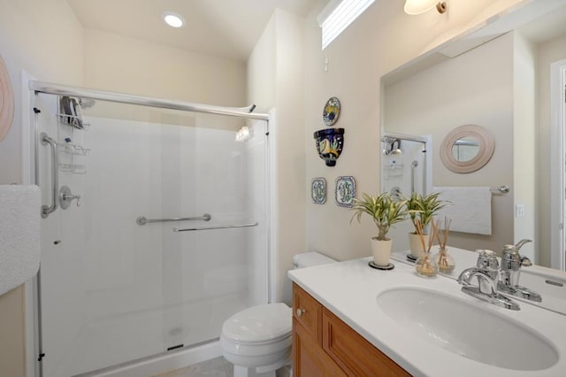 bathroom featuring vanity, toilet, and a shower with door