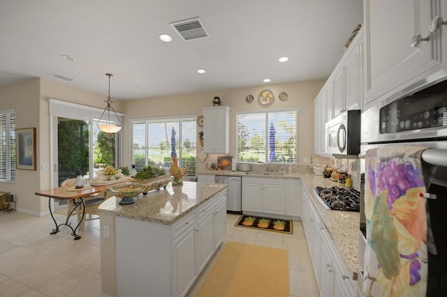 kitchen with white cabinetry, a center island, sink, decorative light fixtures, and appliances with stainless steel finishes