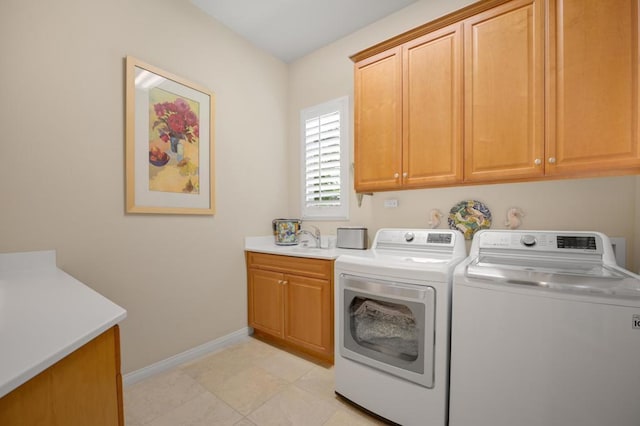 washroom with cabinets, sink, and washer and dryer