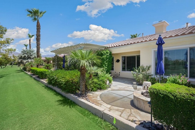 rear view of house featuring a lawn and a patio